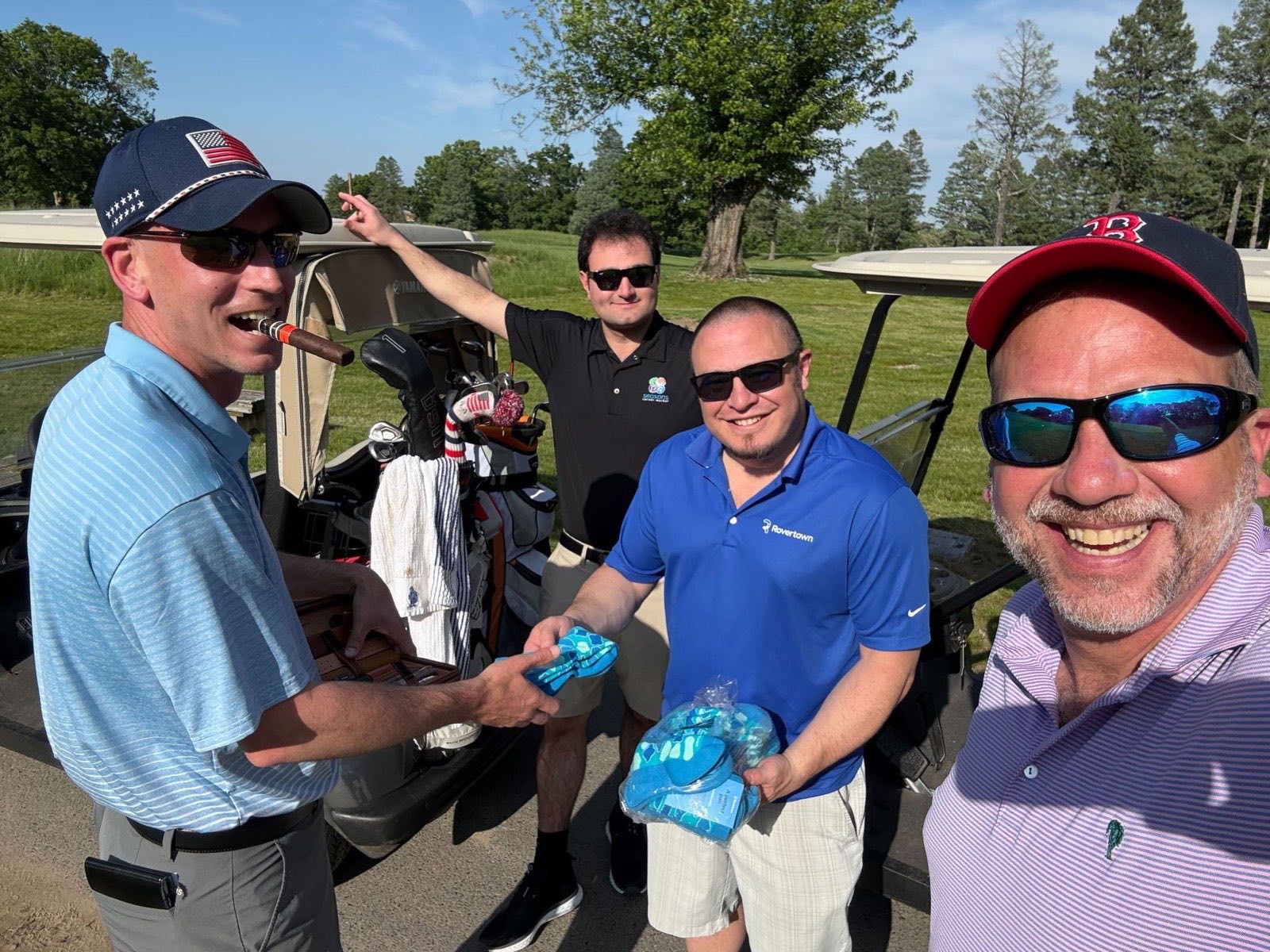 Four people on a golf course handing out Rovertown socks from a golf cart